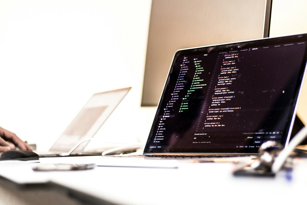 person writing code on notebook